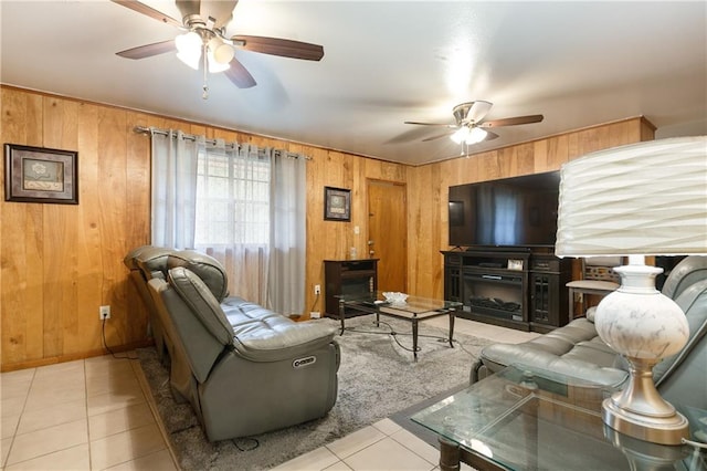 living room with wooden walls, ceiling fan, and light tile patterned floors