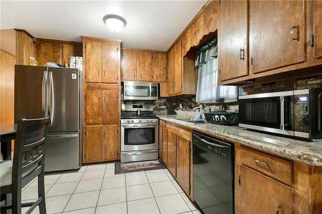 kitchen featuring light tile patterned flooring, appliances with stainless steel finishes, tasteful backsplash, and sink