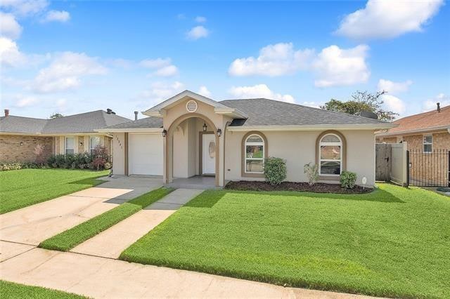 ranch-style house with a garage and a front lawn