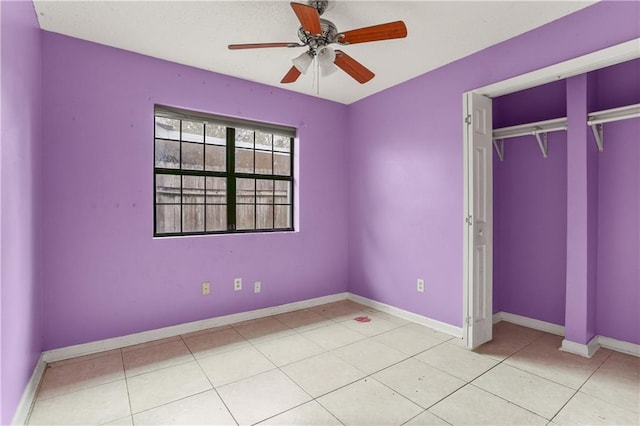 unfurnished bedroom featuring ceiling fan, light tile patterned floors, and a closet