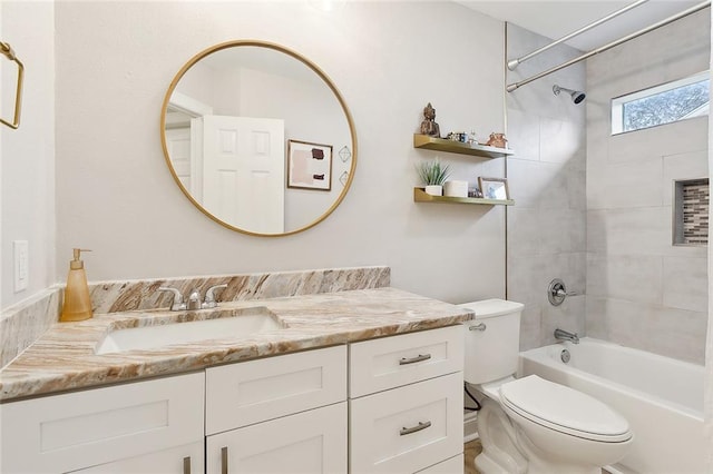 full bathroom featuring tiled shower / bath combo, vanity, and toilet