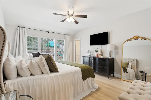 bedroom featuring ceiling fan, light hardwood / wood-style flooring, and lofted ceiling