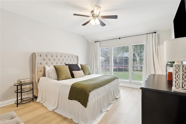 bedroom featuring ceiling fan, lofted ceiling, and light wood-type flooring