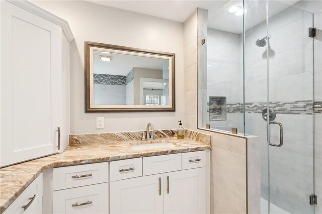 bathroom with vanity and a shower with door