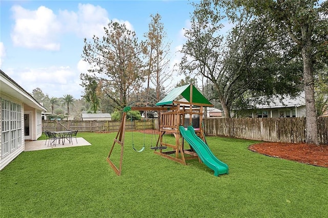 view of playground featuring a patio area and a lawn