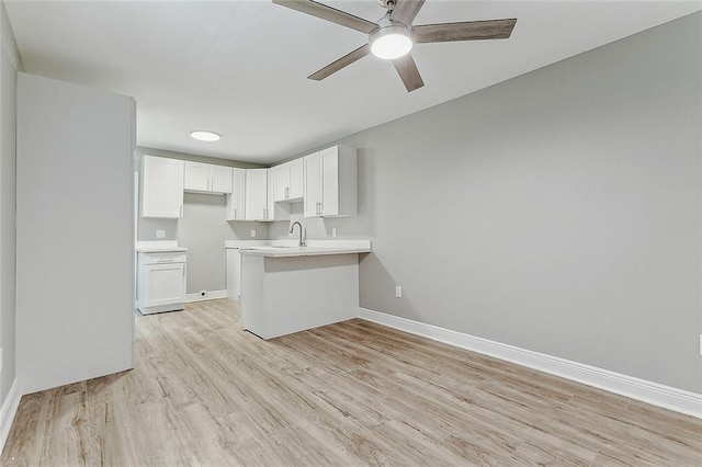 kitchen featuring white cabinets, kitchen peninsula, light hardwood / wood-style flooring, and ceiling fan