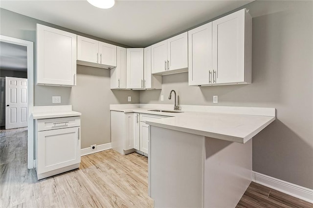 kitchen featuring sink, white cabinets, and light hardwood / wood-style floors