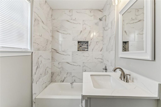 bathroom featuring vanity and tiled shower / bath