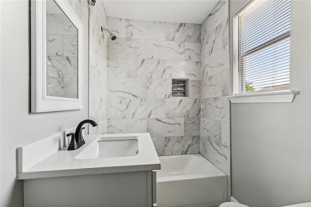 full bathroom featuring toilet, vanity, and tiled shower / bath combo