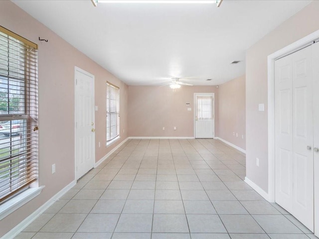 tiled empty room featuring ceiling fan