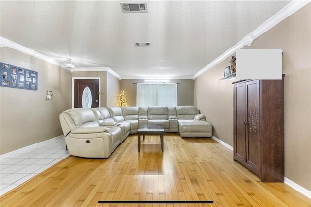 living room with a textured ceiling, crown molding, and light hardwood / wood-style flooring