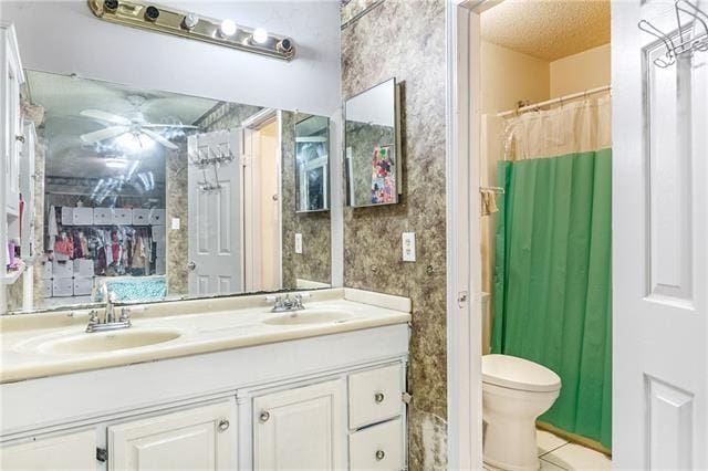 bathroom with curtained shower, tile patterned floors, a textured ceiling, toilet, and vanity