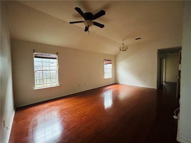 unfurnished room featuring wood-type flooring, ceiling fan with notable chandelier, vaulted ceiling, and a wealth of natural light