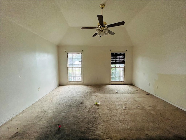 carpeted empty room featuring a textured ceiling, ceiling fan, and vaulted ceiling