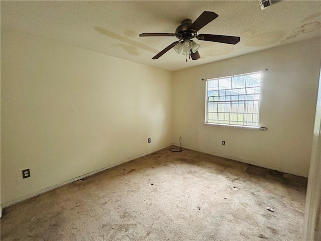 carpeted empty room with ceiling fan and a textured ceiling