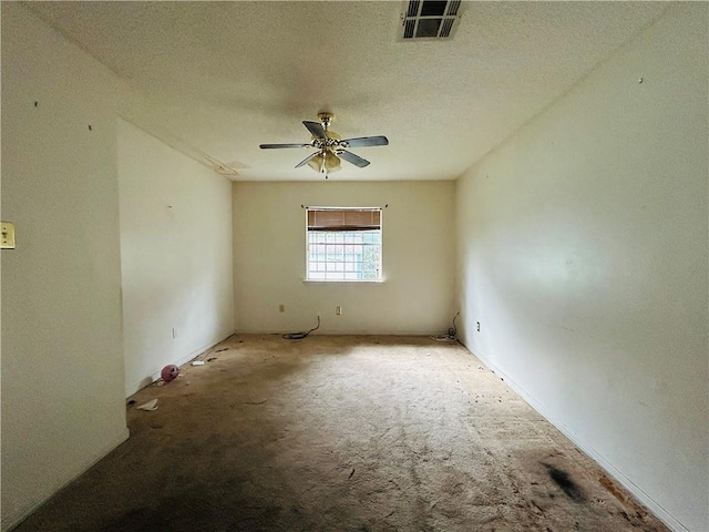 unfurnished room with a textured ceiling, ceiling fan, and light carpet