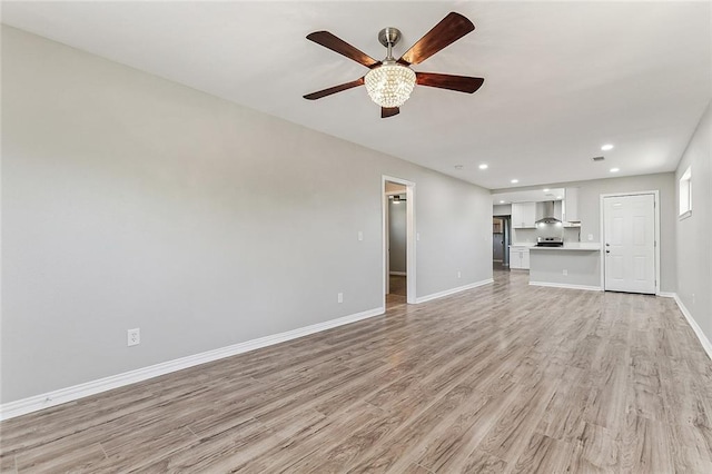 unfurnished living room featuring ceiling fan and light wood-type flooring