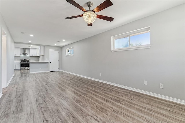 unfurnished living room with ceiling fan and light wood-type flooring