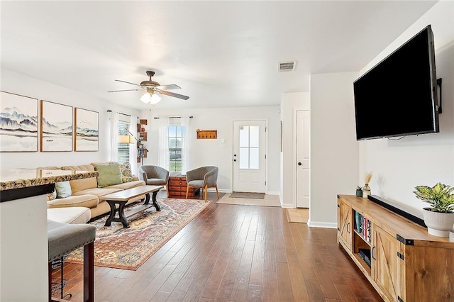 living room featuring ceiling fan and dark hardwood / wood-style flooring