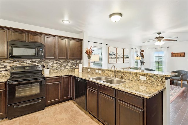 kitchen with kitchen peninsula, sink, black appliances, and light hardwood / wood-style flooring