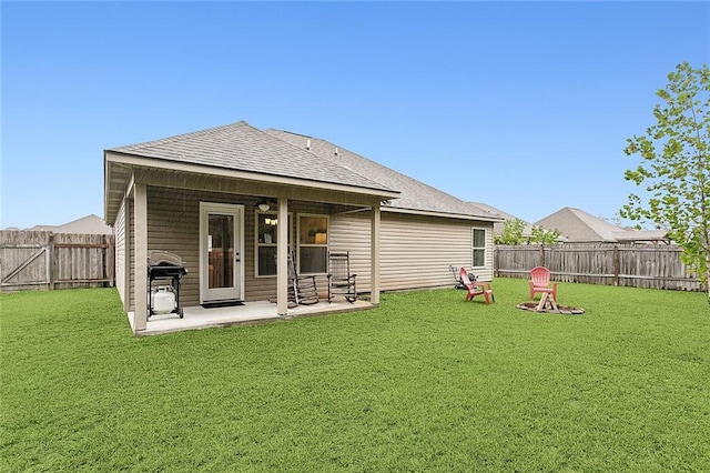 back of property with a yard and a patio