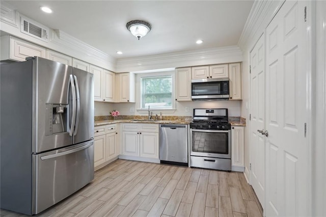 kitchen featuring stainless steel appliances, crown molding, light hardwood / wood-style floors, and sink