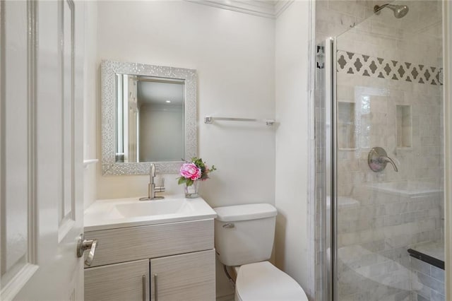 bathroom featuring ornamental molding, vanity, a shower with shower door, and toilet