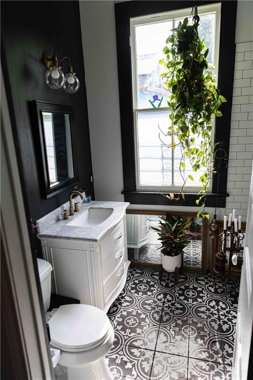 bathroom featuring tile patterned flooring, plenty of natural light, toilet, and vanity