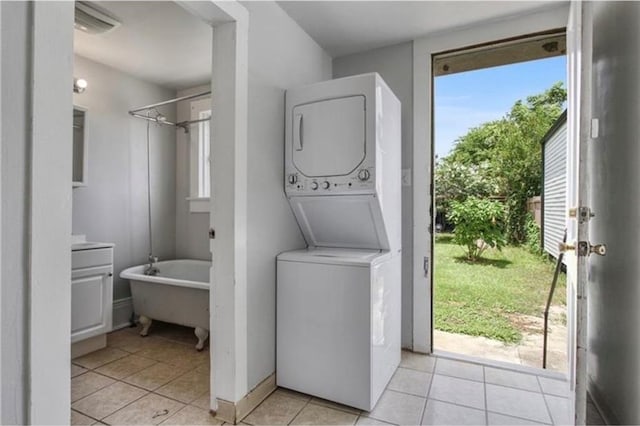 laundry room with stacked washing maching and dryer and light tile patterned flooring