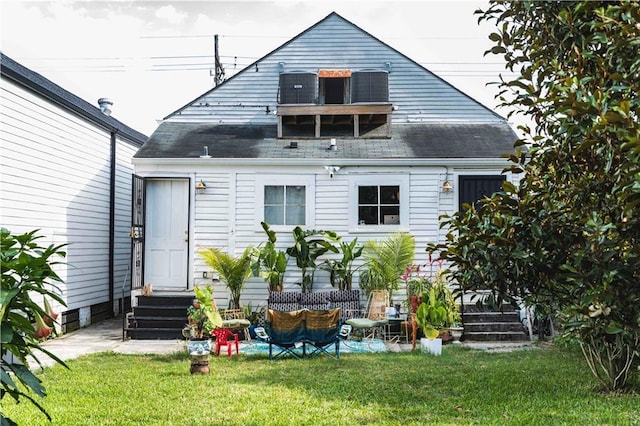 back of property with a yard and central air condition unit