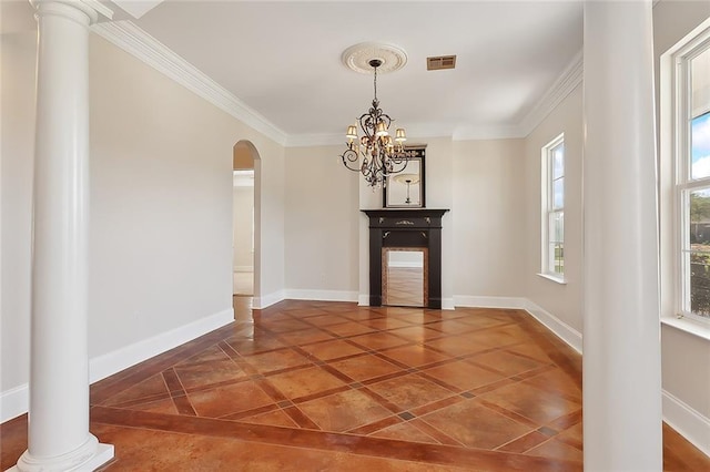 interior space featuring dark tile patterned floors, ornate columns, ornamental molding, and an inviting chandelier