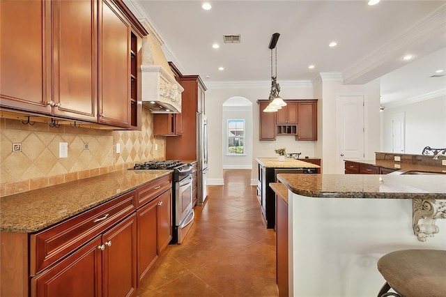 kitchen featuring a kitchen bar, light stone counters, custom range hood, stainless steel appliances, and pendant lighting