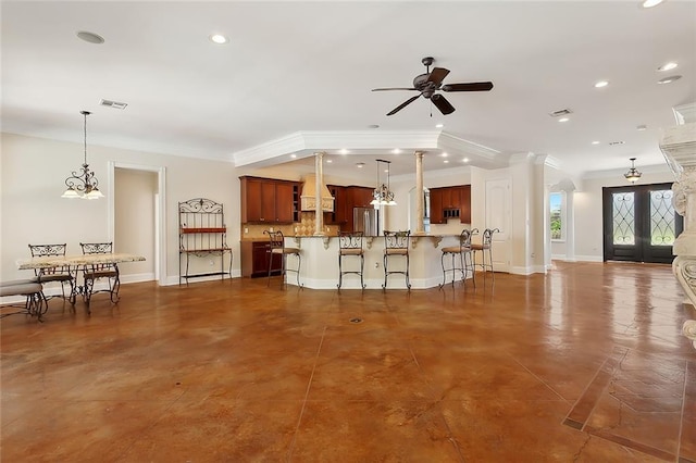 kitchen with french doors, a breakfast bar, ceiling fan, crown molding, and pendant lighting