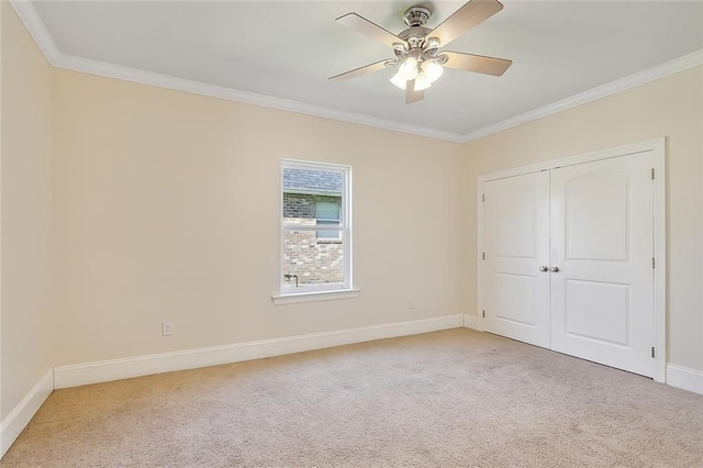 unfurnished bedroom featuring ceiling fan, crown molding, and light colored carpet