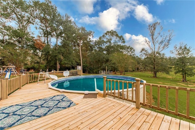 view of swimming pool featuring a yard and a deck