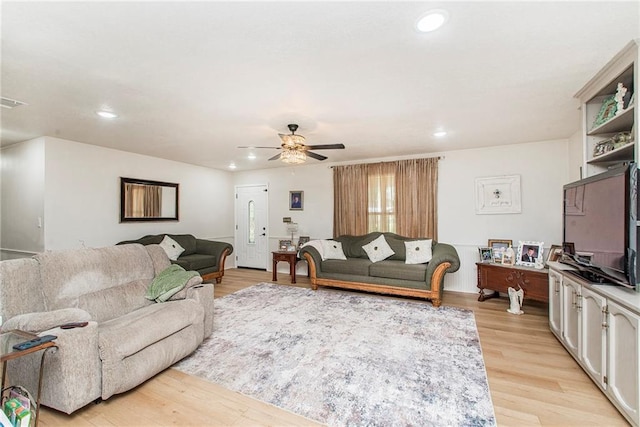 living room with ceiling fan and light hardwood / wood-style flooring