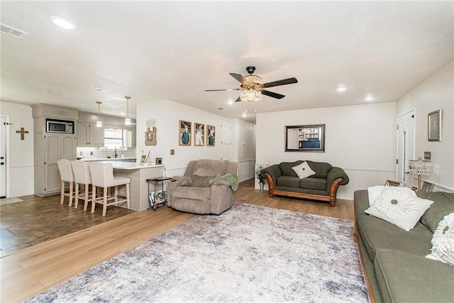 living room featuring ceiling fan and hardwood / wood-style floors