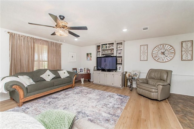 living room with light wood-type flooring and ceiling fan