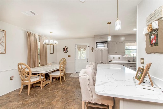 dining area featuring a chandelier and sink