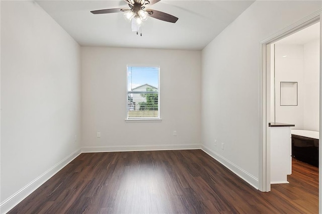 empty room with dark hardwood / wood-style floors and ceiling fan