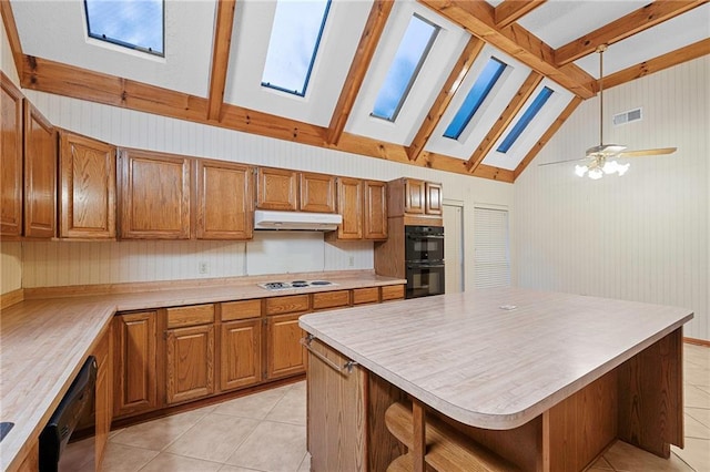 1391 E Ashton Ct, Slidell, LA 70460 - kitchen featuring a skylight, black appliances, light tile patterned floors, and brown cabinets