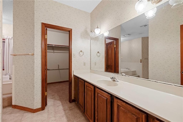 1391 E Ashton Ct, Slidell, LA 70460 - bathroom featuring vanity, tile patterned flooring, wallpapered walls, a spacious closet, and toilet
