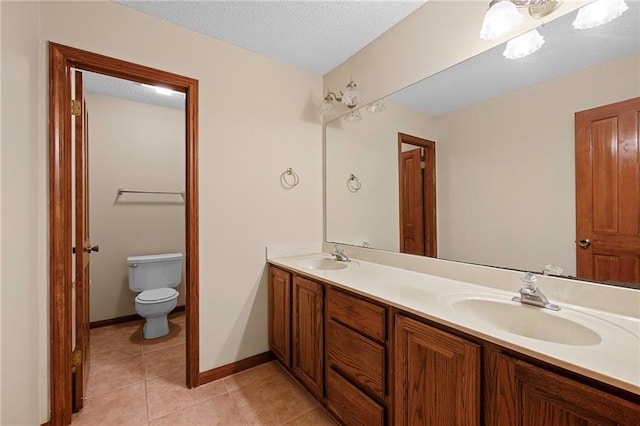 1391 E Ashton Ct, Slidell, LA 70460 - bathroom with double vanity, toilet, tile patterned floors, baseboards, and a textured ceiling