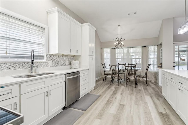 kitchen featuring dishwasher, sink, a notable chandelier, decorative light fixtures, and white cabinets