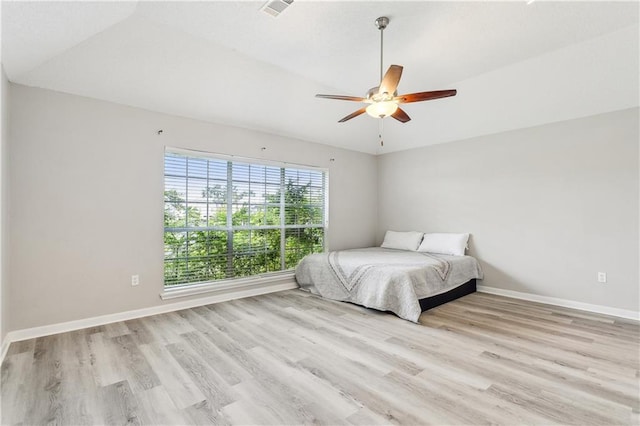 bedroom with light hardwood / wood-style flooring, ceiling fan, and lofted ceiling