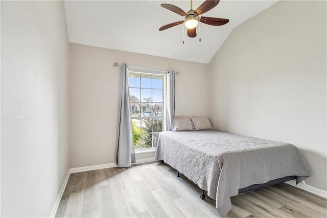 bedroom featuring light hardwood / wood-style flooring, vaulted ceiling, and ceiling fan