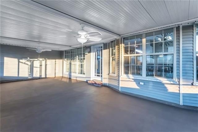 unfurnished sunroom featuring ceiling fan