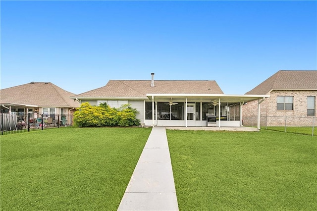 rear view of house featuring a sunroom, a yard, and ceiling fan