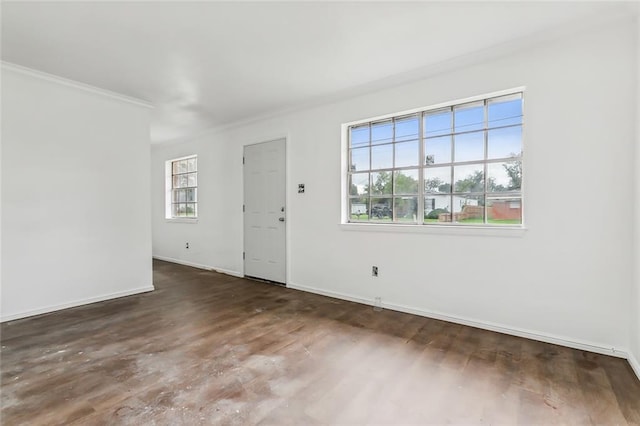 empty room with ornamental molding and dark wood-type flooring