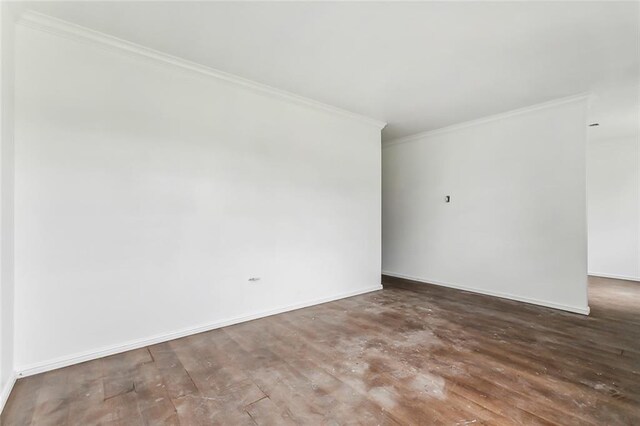 empty room with hardwood / wood-style floors and ornamental molding